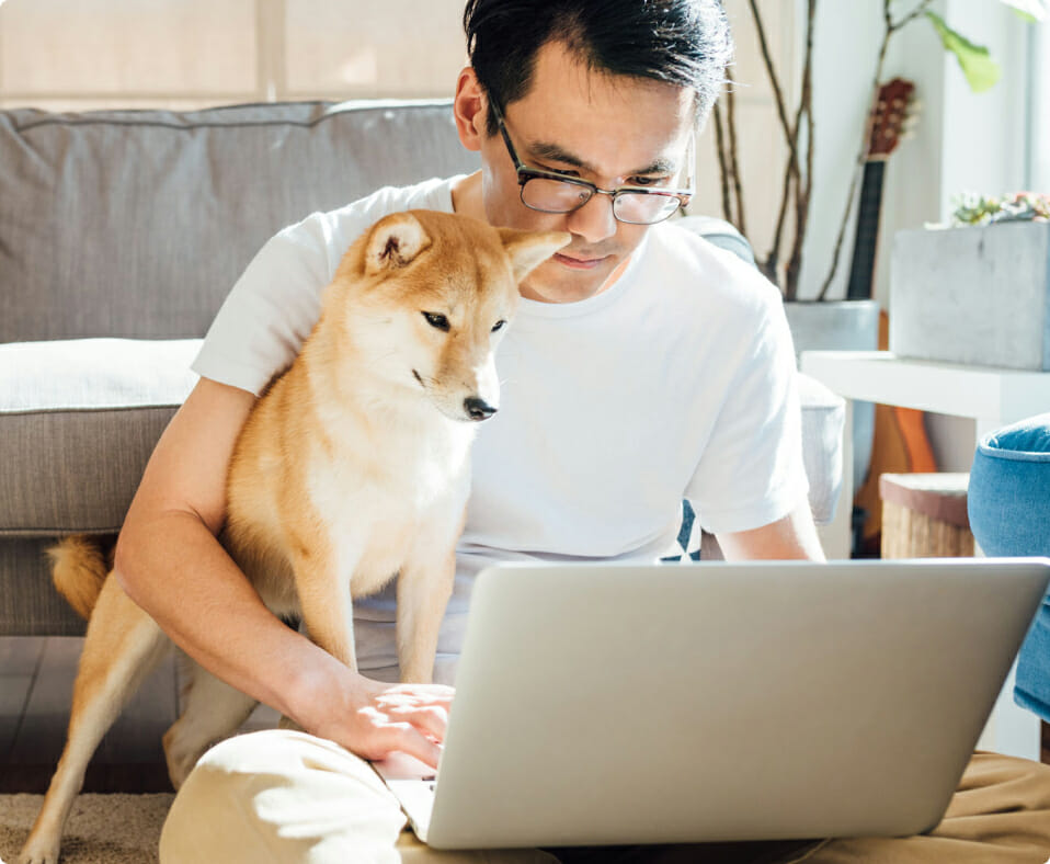 Man using a laptop to work on continuing education courses with dog in his lap